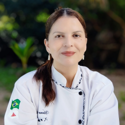 Chef Virna Paulino, jaleco branco com bandeiras do Brasil e Minas Gerais bordadas